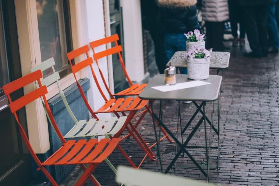 Leere Bistrostühle auf nassem Pflaster
