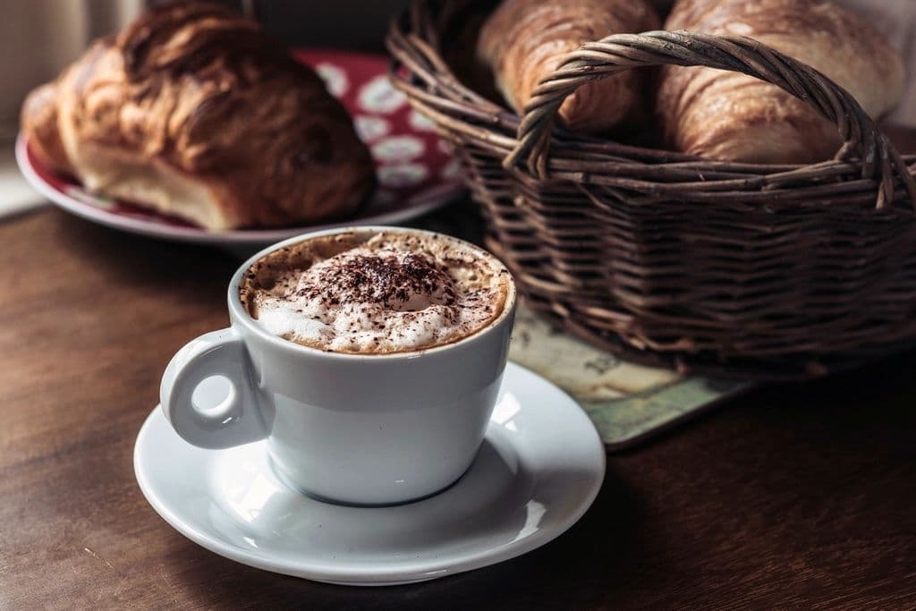 Cappuccino neben einem Brotkorb