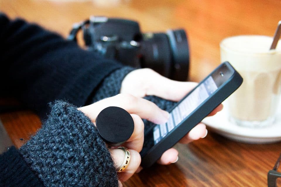 Telefon in der Hand am Tisch